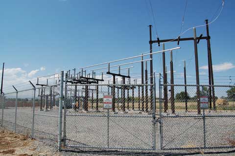 Electric Poles Behind a Fence